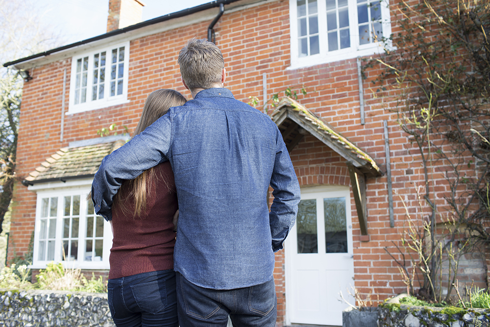 Photo of couple looking at front door of their home