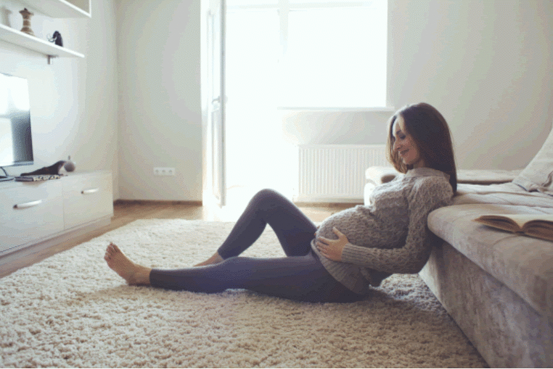 Photo of a pregnant woman sitting on the floor